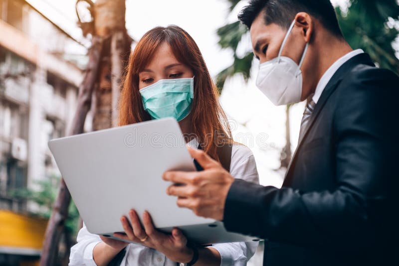 Geschäftsleute, die im Freien arbeiten, tragen eine Schutzmaske, um Grippe- und Koronavirus-Covid19-Ausbruch zu verhindern