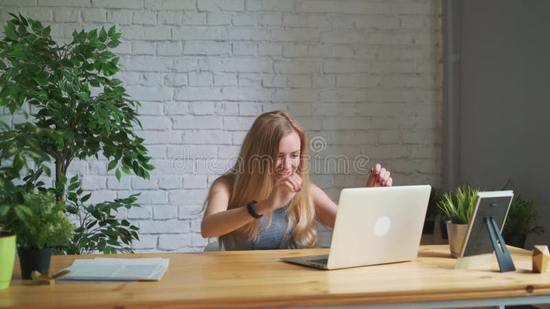 Die glückliche Frau, die aufgeregt glaubt, den Laptopschirm betrachtend, der am Arbeitsplatz sitzt, feiert Geschäftserfolg, on-li