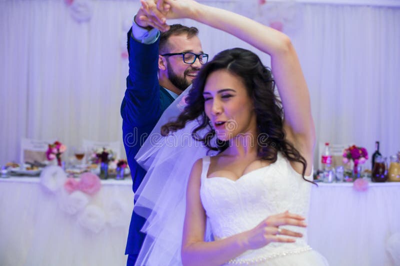 Die glücklichen Jungvermähltenpaare, die Spaß während ihres ersten Tanzes an haben, heiraten lizenzfreie stockfotos Die glücklichen Jungvermähltenpaare, die Spaß während ihres ersten Tanzes an haben, heiraten lizenzfreie stockfotos