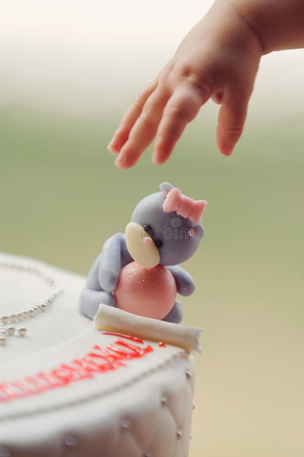 Die Hand des Babys und betreffen Kuchen lizenzfreie stockbilder Die Hand des Babys und betreffen Kuchen lizenzfreie stockbilder