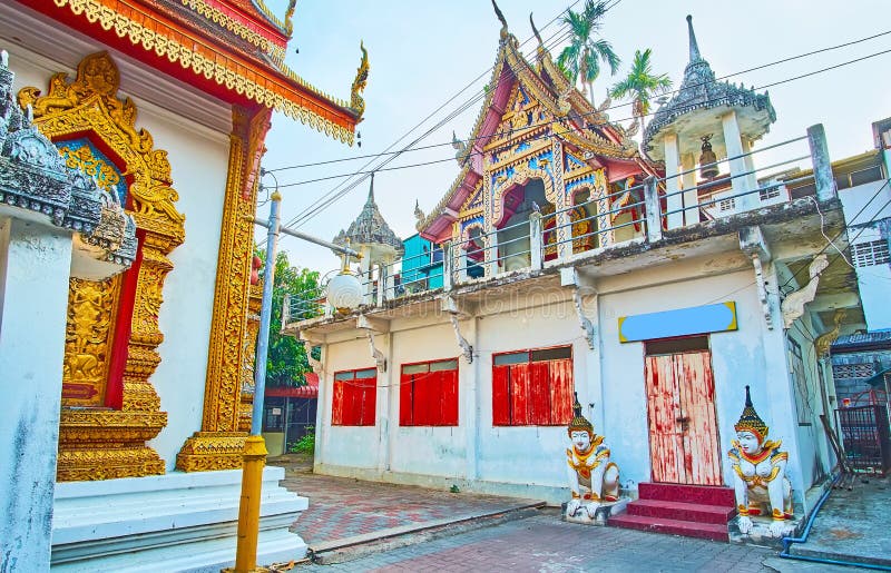 The facade of the old Ho Trai library, manuscript depository building with small bell towers, pyathat roof and Apsonsi human-lion sculptures in front of the entrance, Wat Mai Tang Wat Methang, Chiang Mai, Thailand. The facade of the old Ho Trai library, manuscript depository building with small bell towers, pyathat roof and Apsonsi human-lion sculptures in front of the entrance, Wat Mai Tang Wat Methang, Chiang Mai, Thailand