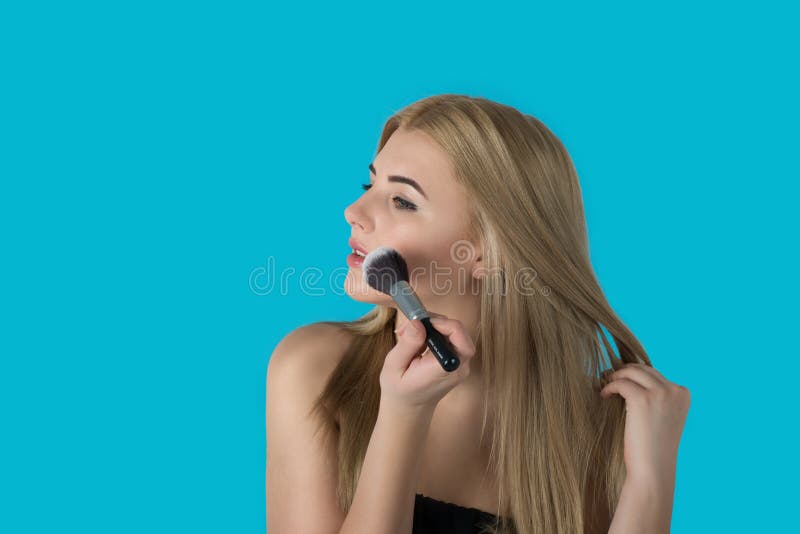 Die junge Frau die Blondine mit brushe für ein Make-up stockbilder Die junge Frau die Blondine mit brushe für ein Make-up stockbilder