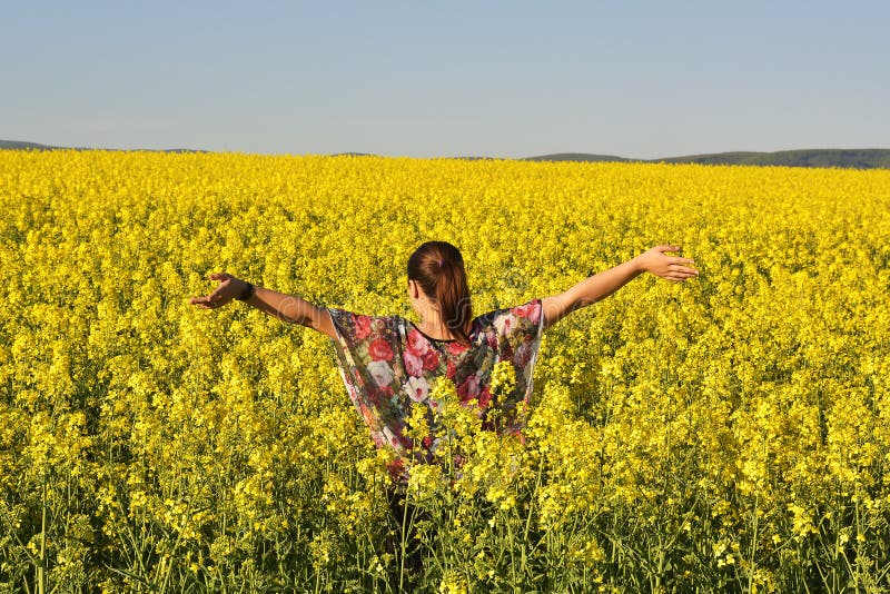 Die junge glückliche Frau auf blühendem Rapssamen fangen im Frühjahr auf stockfotografie Die junge glückliche Frau auf blühendem Rapssamen fangen im Frühjahr auf stockfotografie