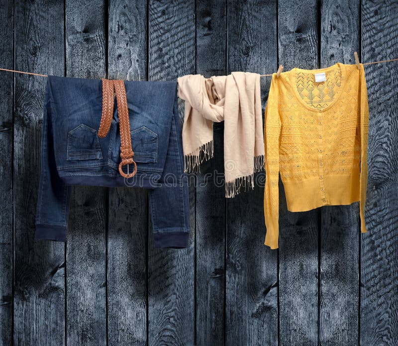 Die Kleidung der Frauen auf einer Wäscheleine auf hölzernem Hintergrund stockfotos Die Kleidung der Frauen auf einer Wäscheleine auf hölzernem Hintergrund stockfotos