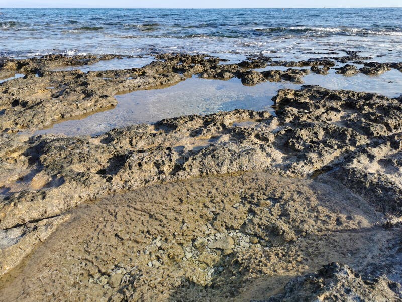 Die Küste des Mittelmeers lange gefrorene Lava in den Nischen, in denen Wasser spritzt lizenzfreies stockbild