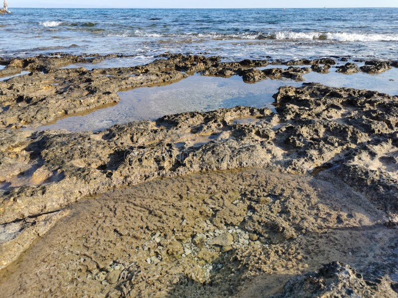 Die Küste des Mittelmeers lange gefrorene Lava in den Nischen, in denen Wasser spritzt lizenzfreies stockfoto
