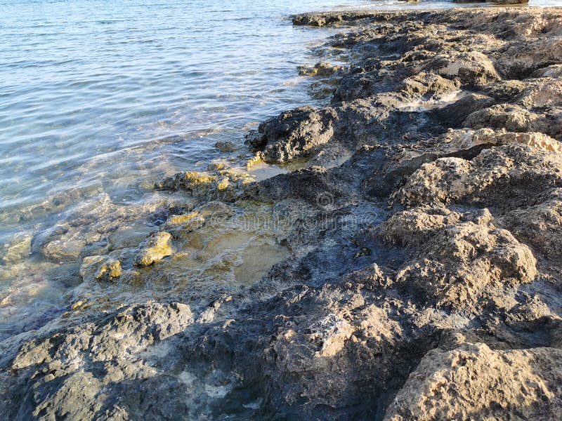 Die Küste des Mittelmeers lange gefrorene Lava in den Nischen, in denen Wasser spritzt stockfotografie