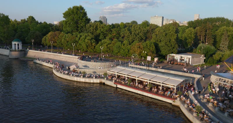 Die Leute gehen am Ufer des Moskauer Flusses entlang in einem wunderschönen Park