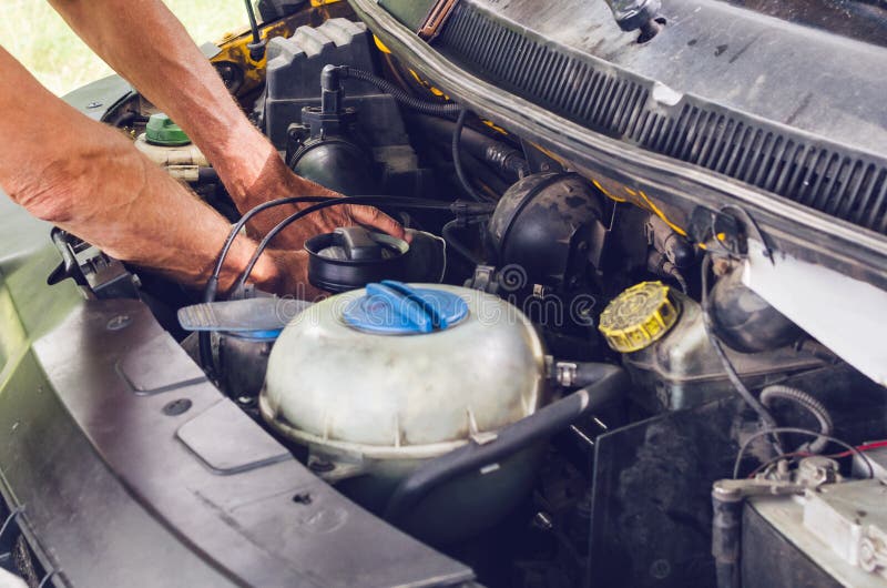 Die Mechaniker ` s Hände, die einen Automotor durchführen, überprüfen stockfoto Die Mechaniker ` s Hände, die einen Automotor durchführen, überprüfen stockfoto
