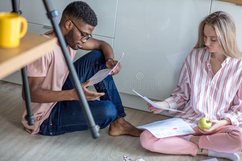Die Mischrassestudenten, die zusammen auf Küchenboden bereiten sitzen zu Hause sich, zu den Prüfungen vor stockfotos Die Mischrassestudenten, die zusammen auf Küchenboden bereiten sitzen zu Hause sich, zu den Prüfungen vor stockfotos