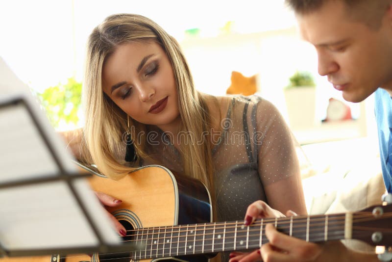 Die Musik, die Lektions-Liebhaber spielt, verbindet am Wohnzimmer lizenzfreies stockbild Die Musik, die Lektions-Liebhaber spielt, verbindet am Wohnzimmer lizenzfreies stockbild