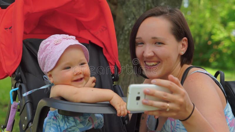 Die Mutter macht selfie an einem Handy mit einem Kind
