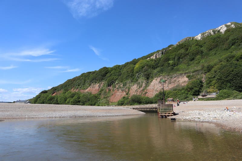 Die Mündung der Flussaxt, wenn sie auf das Meer in axmouth in devon trifft. Er ist recht eng und wird bei Ebbe zu einem wütenden G. Er ist ziemlich eng und wird bei Gezeitenwechsel zu einem tosenden Gefälle.