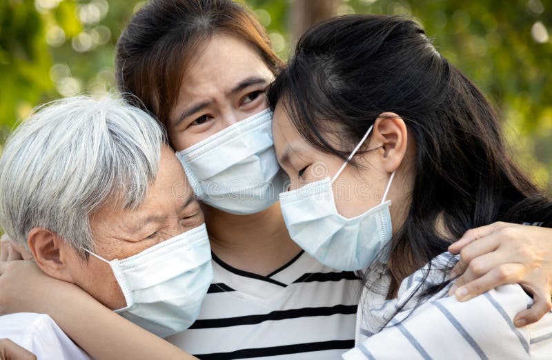 Die niedergedrückte asiatische Familie, die die medizinische Maske schreit trägt, leiden unter Trauer, der große Verlust ihrer Fa