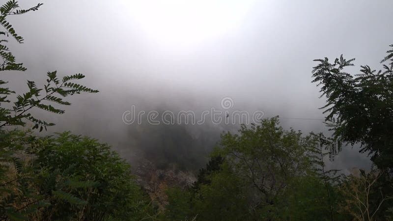 Die Person geht über die Klippe hinunter, Wolken steigen hoch