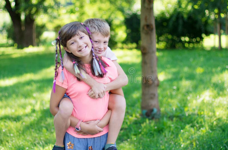 Die Schwester trägt ihren kleinen Bruder im Park auf der Schulter lizenzfreies stockfoto