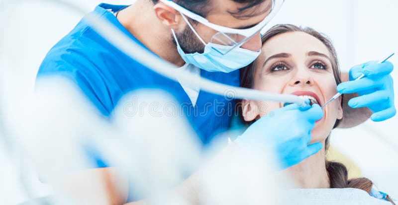 Die schöne junge Frau, die oben schaut, entspannte sich während eines schmerzlosen zahnmedizinischen Verfahrens lizenzfreie stockfotografie Die schöne junge Frau, die oben schaut, entspannte sich während eines schmerzlosen zahnmedizinischen Verfahrens lizenzfreie stockfotografie