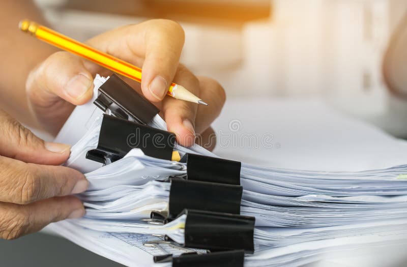 Die suchenden und überprüfenden Geschäftsmannhände schreiben unfertige Belegstapel Papierarchive auf Schreibtisch für Berichtspap