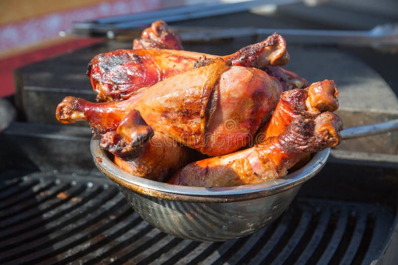 Die Türkei-Beine gebacken auf Kohlen in einer Metallschüssel auf dem Grill lizenzfreie stockfotos Die Türkei-Beine gebacken auf Kohlen in einer Metallschüssel auf dem Grill lizenzfreie stockfotos