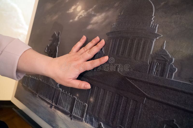 The female hand touches a special relief picture for the visually impaired. The female hand touches a special relief picture for the visually impaired