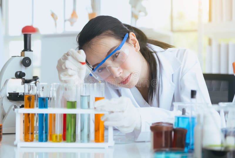 Scientist beautiful asian woman working and putting medical chemicals sample in test tube at lab office,Close up. Scientist beautiful asian woman working and putting medical chemicals sample in test tube at lab office,Close up