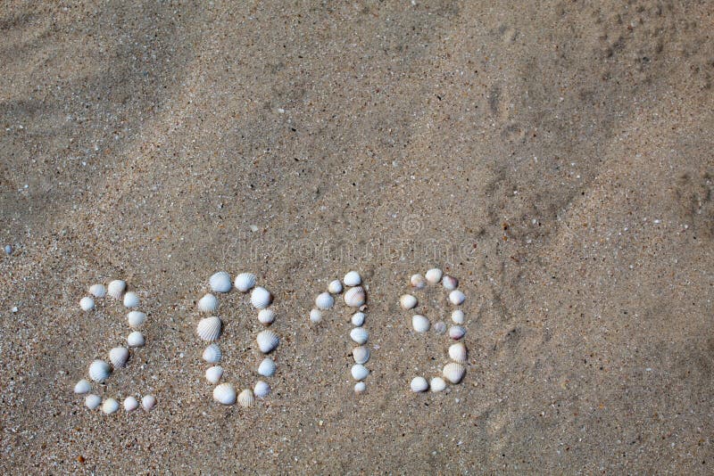 Die Zahl ‚2019 ‚wird auf Sand mit Oberteilen ausgebreitet stockbilder Die Zahl ‚2019 ‚wird auf Sand mit Oberteilen ausgebreitet stockbilder