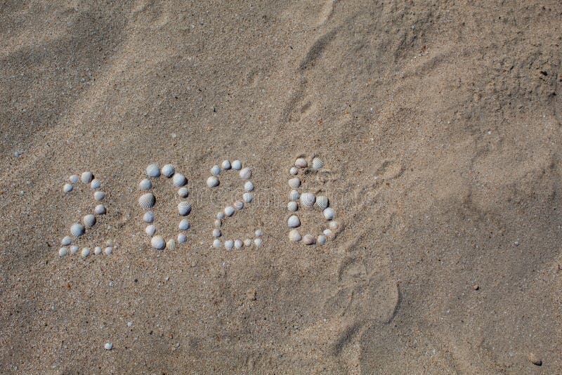 Die Zahl ‚2026 ‚wird auf Sand mit Oberteilen ausgebreitet stockfotos Die Zahl ‚2026 ‚wird auf Sand mit Oberteilen ausgebreitet stockfotos