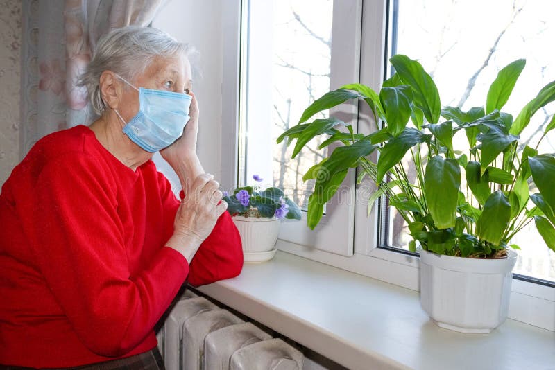 Die ältere alte Einsamen Frau der Sicherheit der Gesundheit covid19 und des Pandemie Konzepts, die in der Nähe des Fenster sitzt