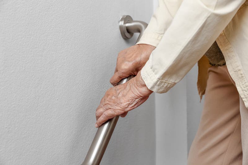 Die ältere Frau, die an Handlauf für Sicherheitsweg hält, tritt stockfotografie Die ältere Frau, die an Handlauf für Sicherheitsweg hält, tritt stockfotografie