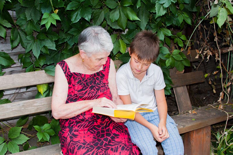 Die ältere Frau mit dem Großenkel las das Buch stockbild Die ältere Frau mit dem Großenkel las das Buch stockbild