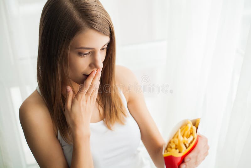 Dieet Vrouw die zich op schalen bevinden en chips houden Het concept het gezonde eten Gezonde Levensstijl Dieet royalty-vrije stock afbeeldingen Dieet Vrouw die zich op schalen bevinden en chips houden Het concept het gezonde eten Gezonde Levensstijl Dieet royalty-vrije stock afbeeldingen