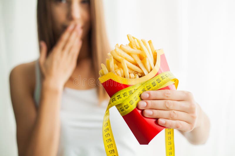 Dieet Vrouw die zich op schalen bevinden en chips houden Het concept het gezonde eten Gezonde Levensstijl Dieet royalty-vrije stock afbeeldingen Dieet Vrouw die zich op schalen bevinden en chips houden Het concept het gezonde eten Gezonde Levensstijl Dieet royalty-vrije stock afbeeldingen