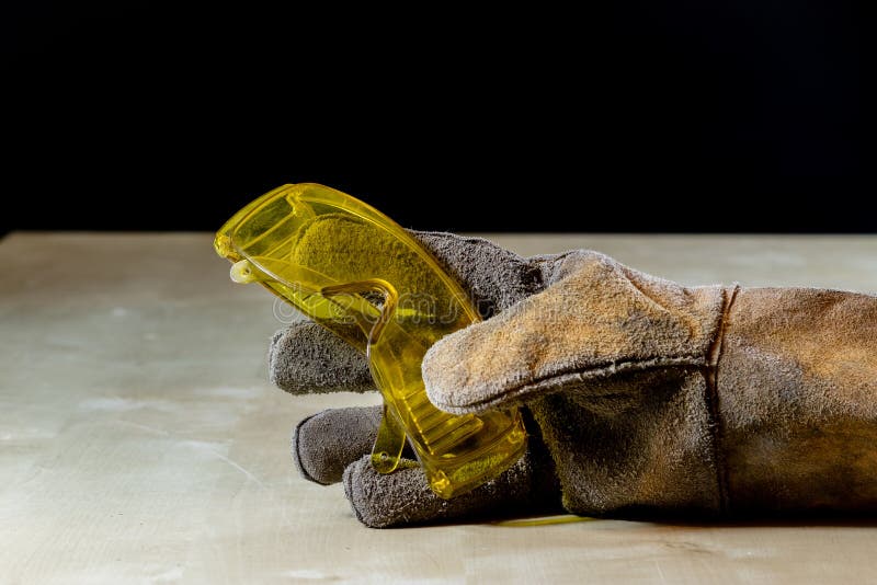 Dien handschoen met hulpmiddel voor het werk in workshop in Langs beschermde hand stock afbeelding Dien handschoen met hulpmiddel voor het werk in workshop in Langs beschermde hand stock afbeelding