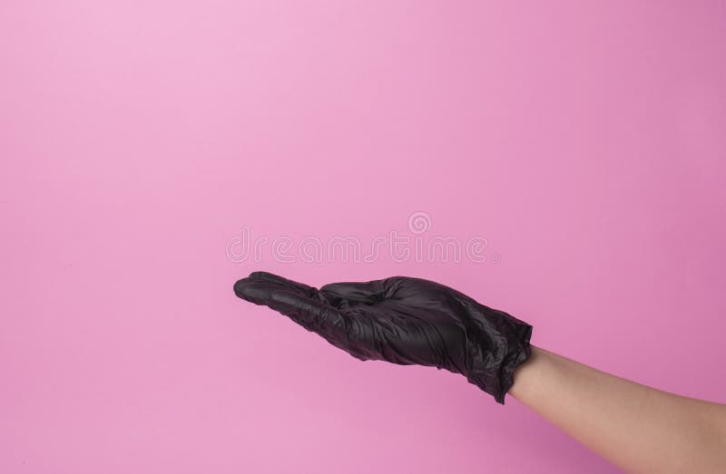 Dien zwarte handschoenen van arts of herenkapper op roze achtergrond in de handschoenen worden gedragen op het wapen royalty-vrije stock afbeelding Dien zwarte handschoenen van arts of herenkapper op roze achtergrond in de handschoenen worden gedragen op het wapen royalty-vrije stock afbeelding