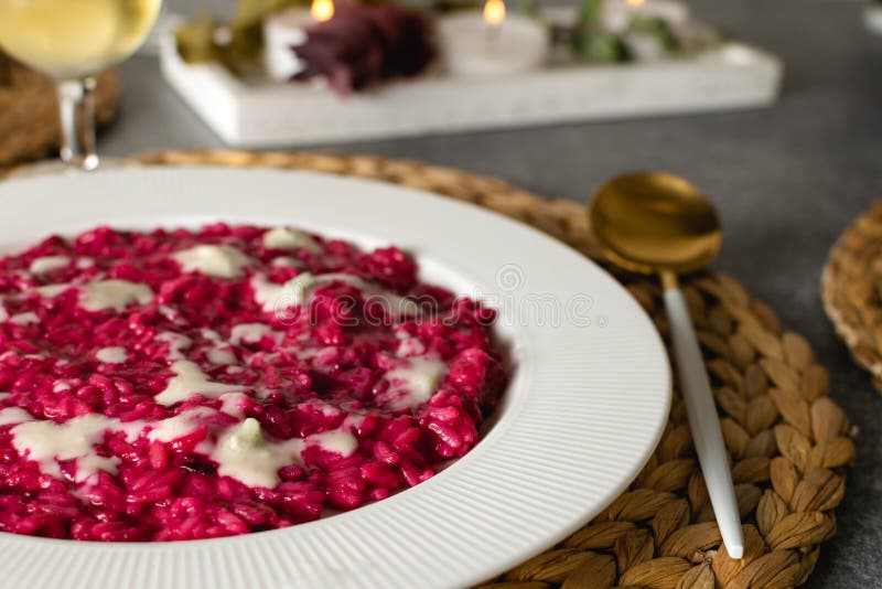 Diende de selectieve nadruk van bietenrisotto met glas witte wijn, gastronomisch Italiaans voedsel royalty-vrije stock fotografie Diende de selectieve nadruk van bietenrisotto met glas witte wijn, gastronomisch Italiaans voedsel royalty-vrije stock fotografie