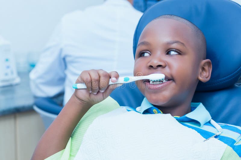 Close up of young boy brushing teeth in the dentists chair. Close up of young boy brushing teeth in the dentists chair