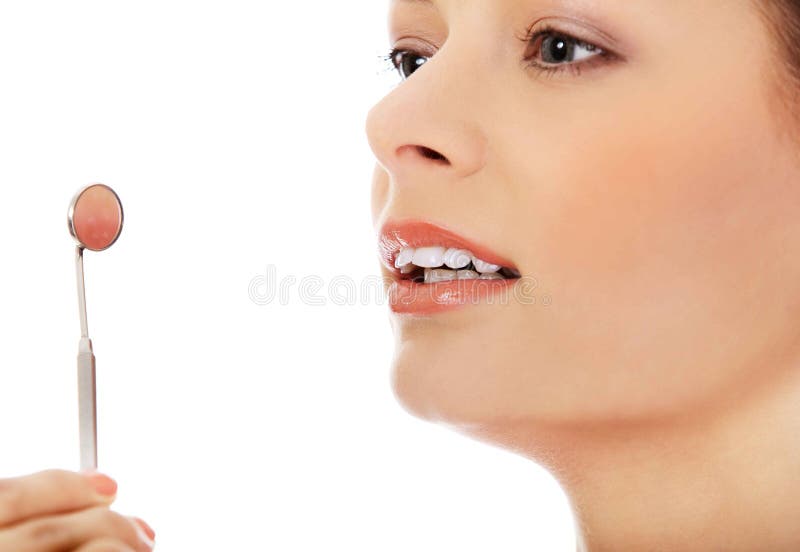 Dientes de la mujer joven y un espejo de boca del dentista foto de archivo Dientes de la mujer joven y un espejo de boca del dentista foto de archivo