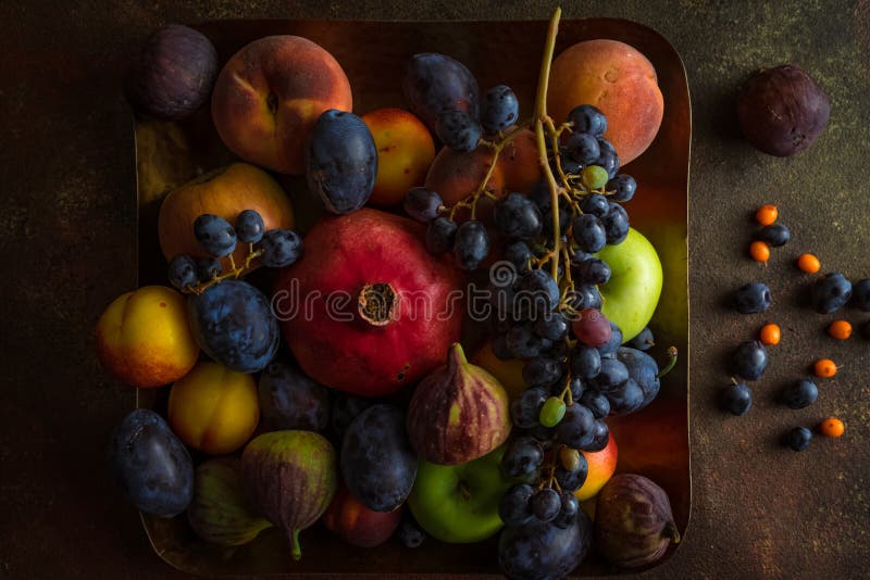 Diersoort van kleurrijk fruit: pomegranaat, druiven, perziken, pruimen, appelen, vijgen op vierkant platter stock foto Diersoort van kleurrijk fruit: pomegranaat, druiven, perziken, pruimen, appelen, vijgen op vierkant platter stock foto