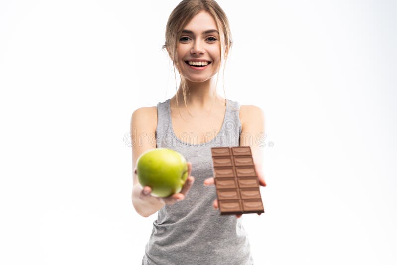 Diet. Dieting concept. Healthy Food. Beautiful Young Woman choosing between Healthy and Unhealthy Food.Fruits or Sweets stock photos Diet. Dieting concept. Healthy Food. Beautiful Young Woman choosing between Healthy and Unhealthy Food.Fruits or Sweets stock photos