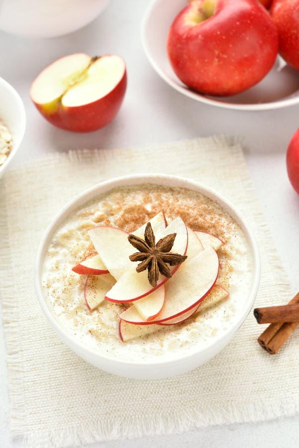 Oatmeal porridge with red apple slices and cinnamon