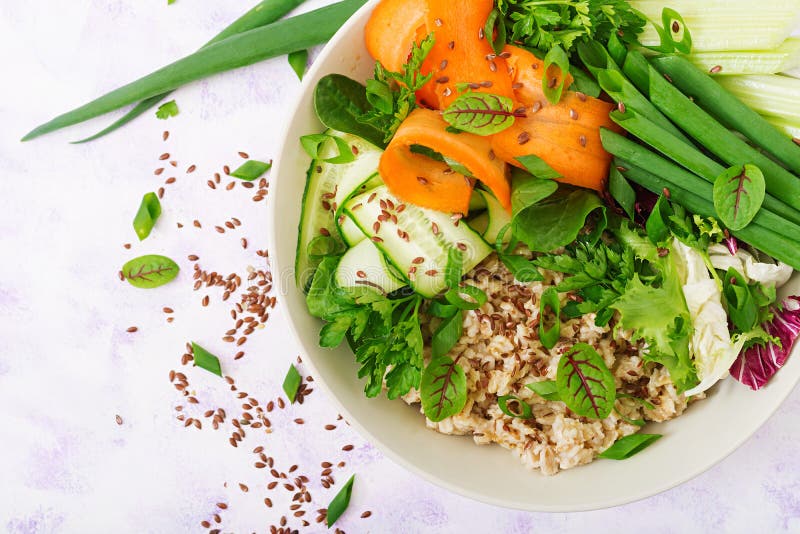 Diet menu. Healthy lifestyle. Oat porridge and fresh vegetables - celery, spinach, cucumber, carrot and onion. Asian, brown.