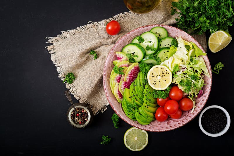 Diet menu. Healthy lifestyle. Vegan salad of fresh vegetables - tomatoes, cucumber, watermelon radish and avocado
