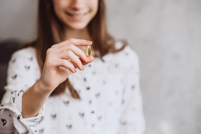 Diet. Nutrition. girl taking pills with cod liver omega-3 oil. The concept of a healthy diet and lifestyle