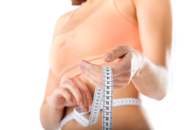 Dieta - la giovane donna sta misurando la sua vita immagini stock Dieta - la giovane donna sta misurando la sua vita immagini stock