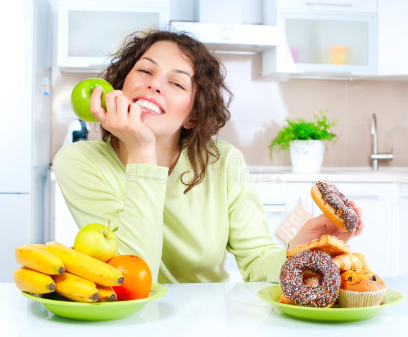 Dieta. Mujer que elige entre las frutas y los dulces