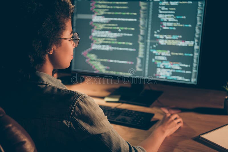 Dietro la vista foto di una donna programmatore di pelle scura con un grande monitor controlla l'indirizzo di lavoro straordinario