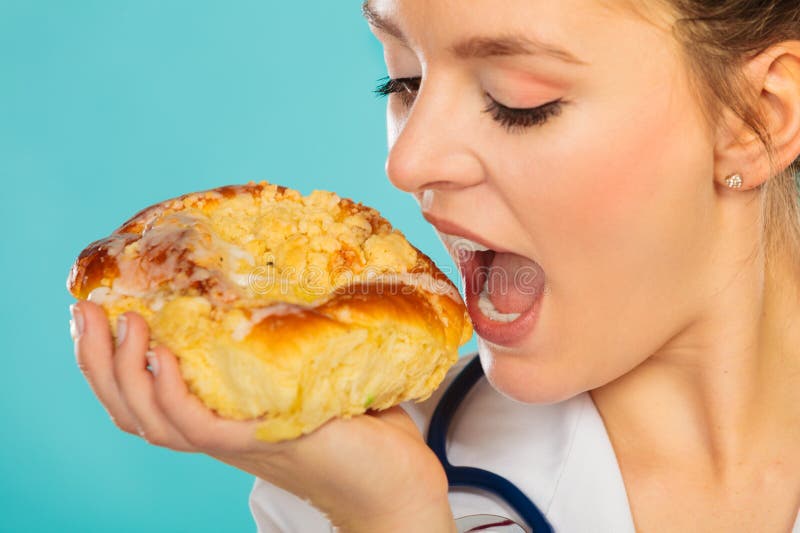 Dietético que come el bollo del rollo dulce Comida de Unhealth imagen de archivo libre de regalías Dietético que come el bollo del rollo dulce Comida de Unhealth imagen de archivo libre de regalías