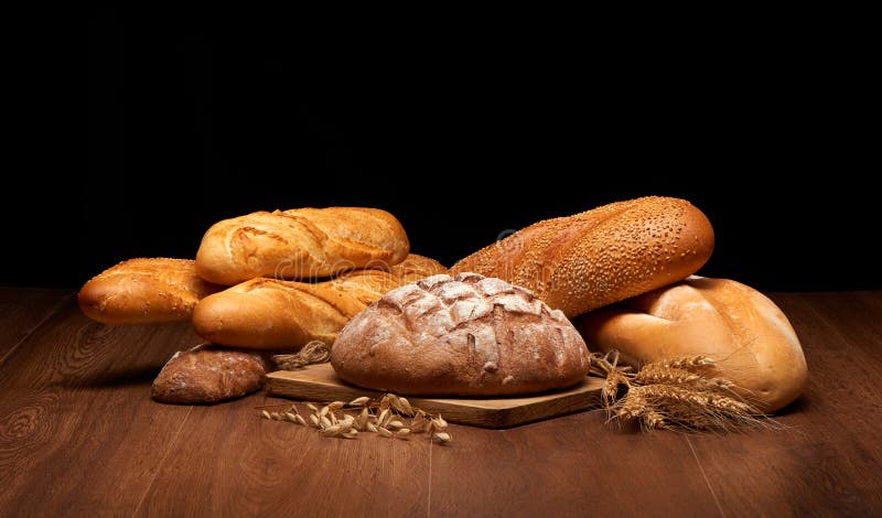 Different bread and wheat on dark wooden table stock photography Different bread and wheat on dark wooden table stock photography