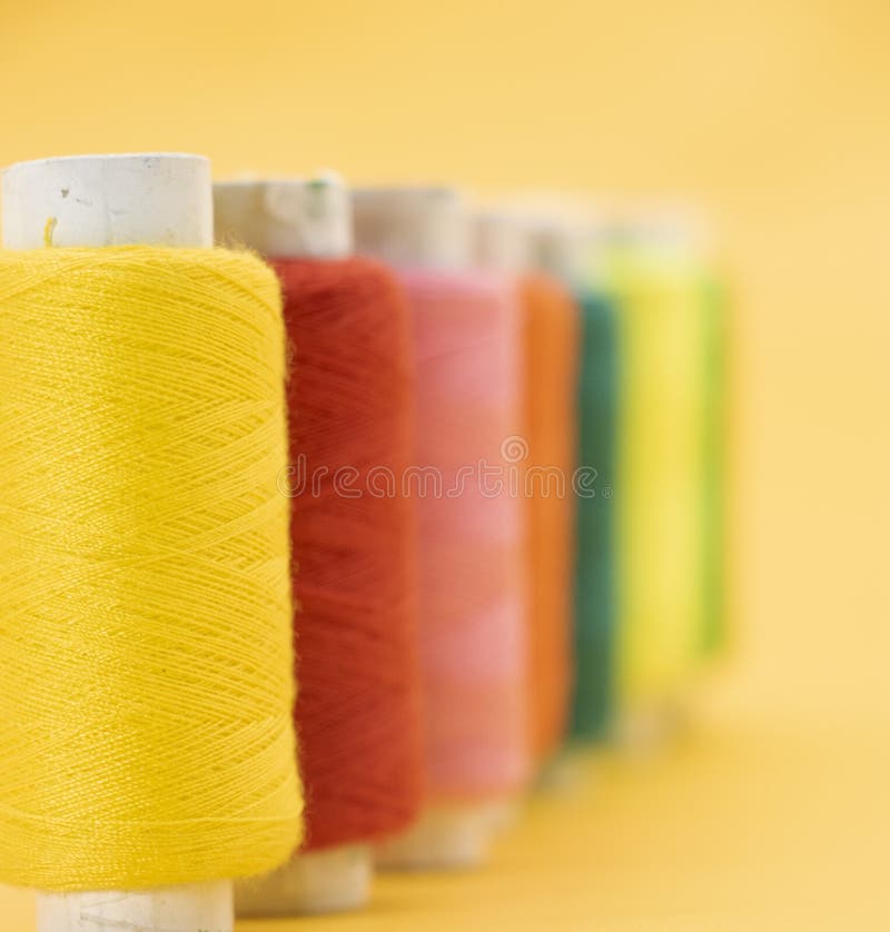 Different Color Yarn or Spool Thread Over on Yellow Background,red