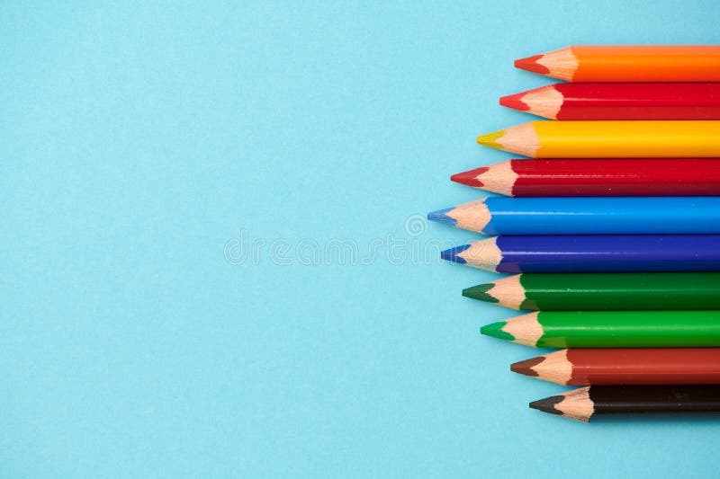 Different Colored Pencils on a Light Blue Background with Space for Any